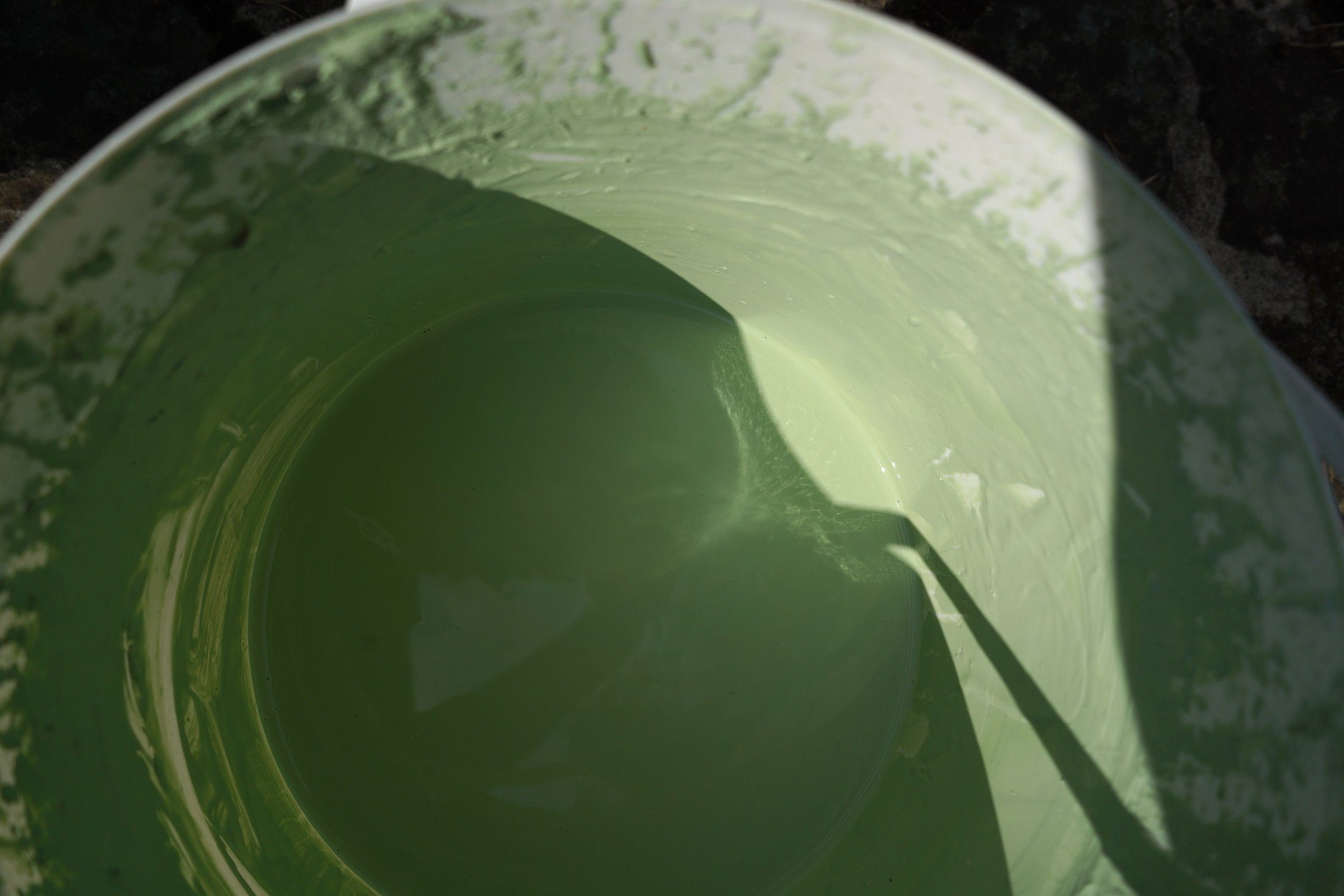 Green glaze prepared in a studio bucket.
