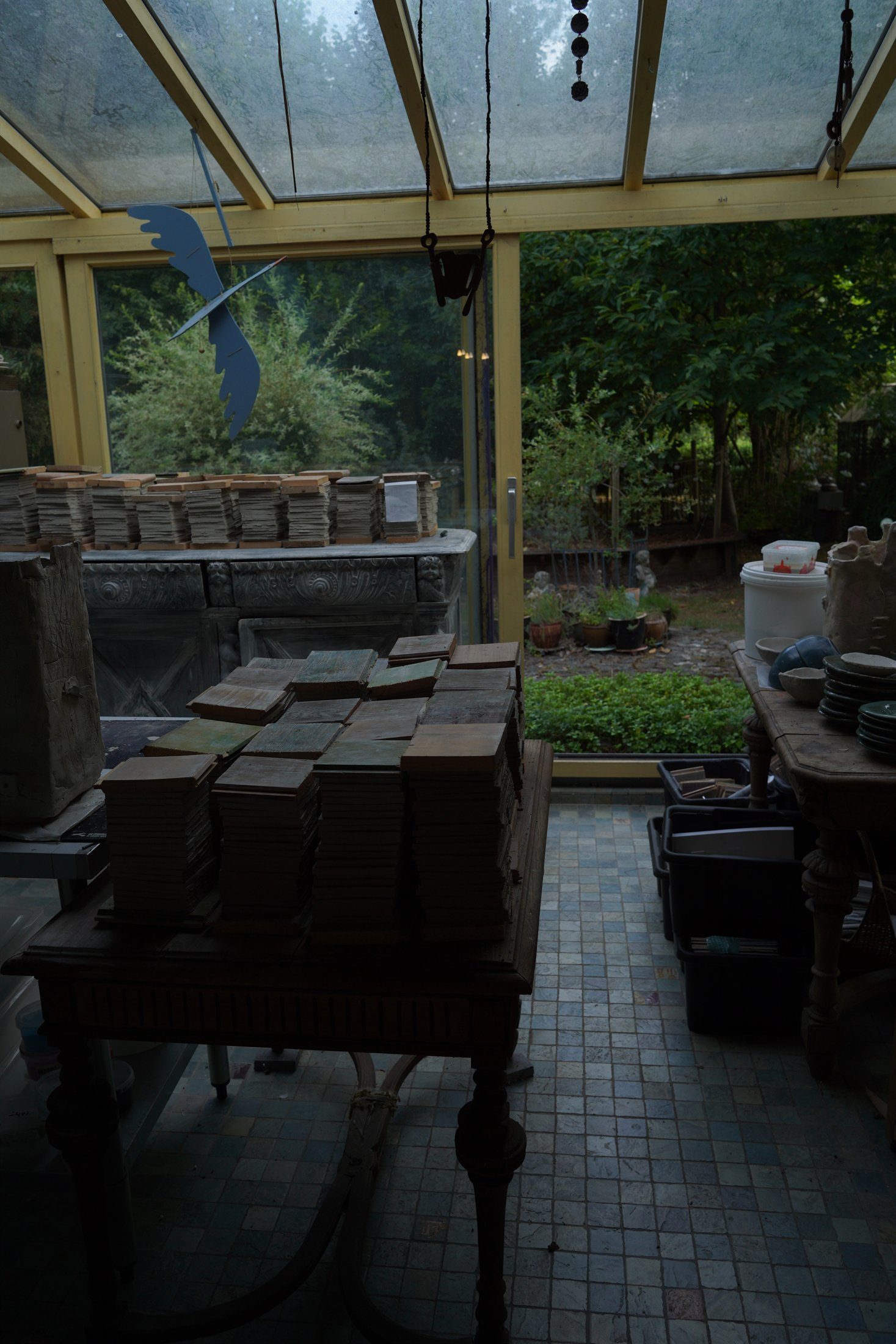 Wide atelier room with stacked tile batches by the window.